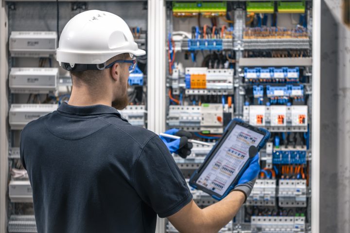 electrician-with-tablet-adjusting-circuitry-junction-box